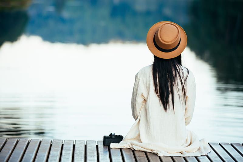 lonely woman sitting waterfront raft